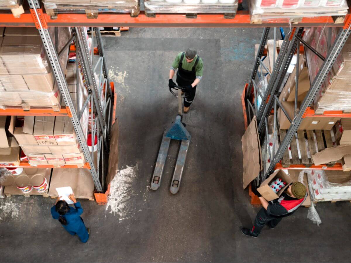 Aerial view of a warehouse with a hand pallet truck prepared for use by a professional warehouse worker.