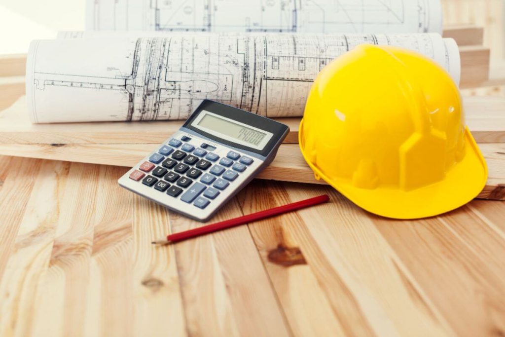 Hard hat, blueprint, and calculator representing cost analysis for purchasing a generator set for construction site operations and planning.