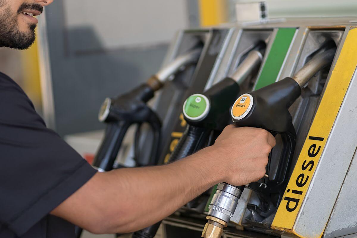 Worker refueling with a diesel pump to represent rising fuel prices and higher forklift operating expenses