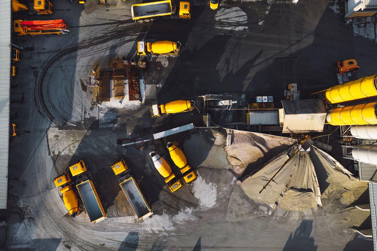 Top view of construction equipment and trucks at a busy site where downtime can disrupt project schedules