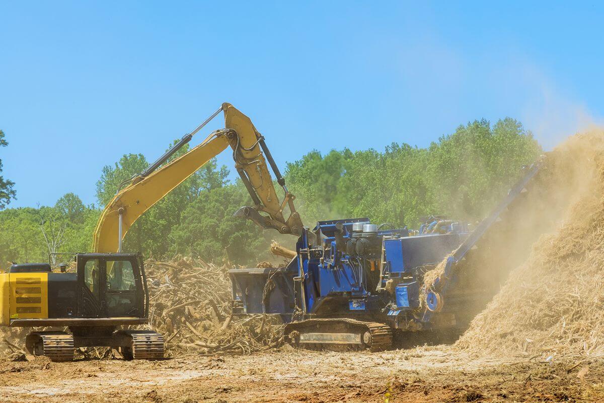 Excavator feeding a mobile crusher on a dusty site to show heavy equipment rental and capacity gaps