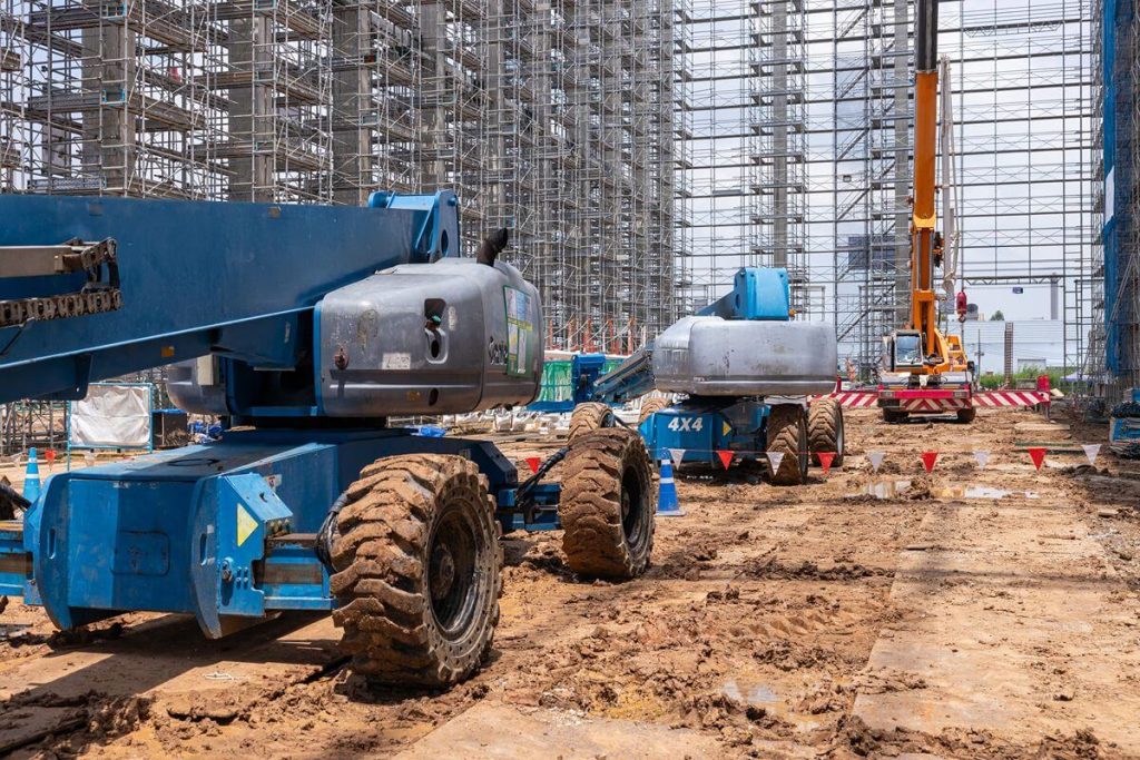 Heavy construction equipment operating on a muddy project site to represent fleet support needs and capacity planning